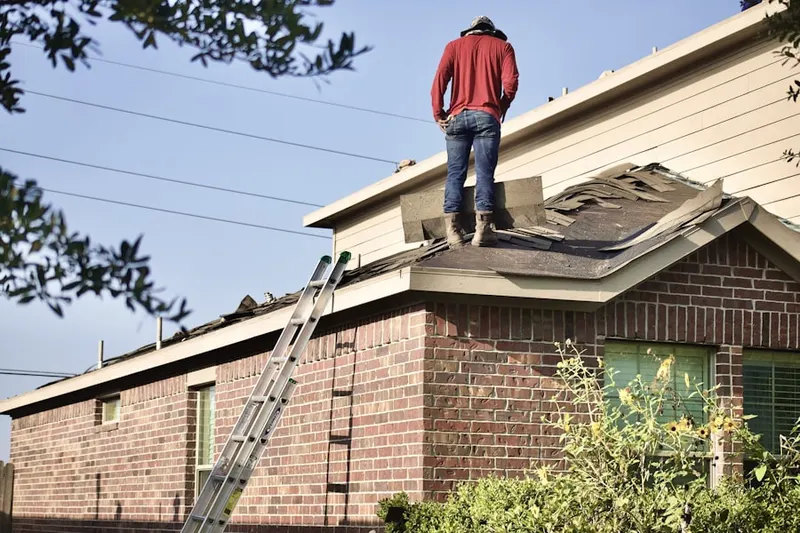 Professional roofer working on a residential roof in Gloucester